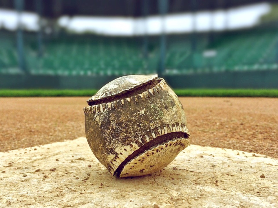 An MLB baseball sitting on home plate.